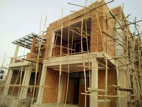 Villa en brique vue d'angle, échafaudage en place